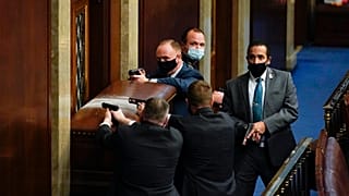Policías del Capitolio defienden con sus armas en la mano una de las entradas de la Cámara de Representantes