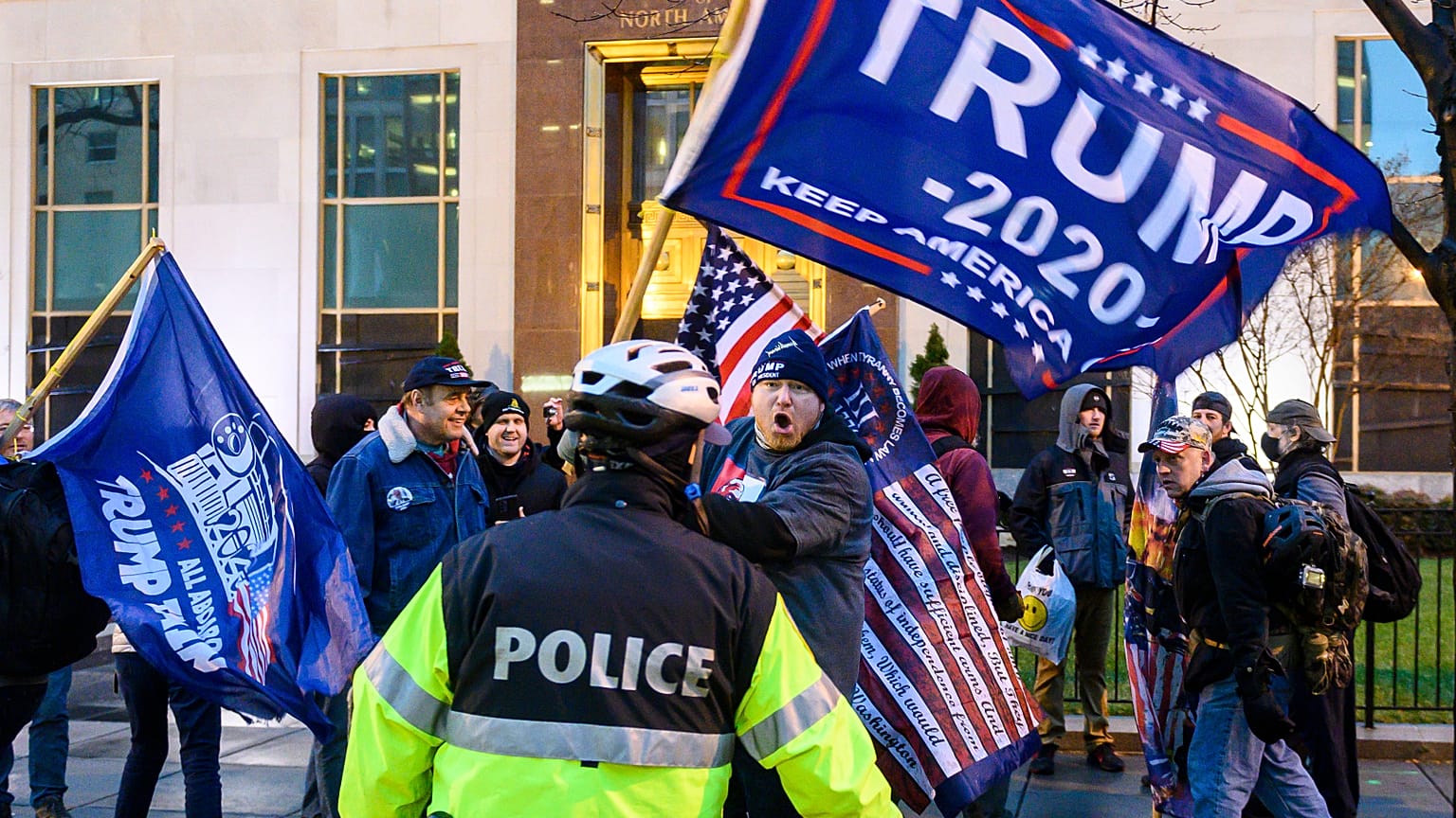Pro-Trump supporters stand behind police as they argue with counter protesters during a confrontation near Black Lives Matter plaza in Washington, DC