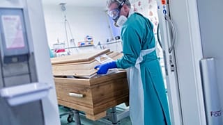 Bestattungsunternehmer Christoph Kuckelkorn schließt einen Sarg in Köln, 18.12.2020