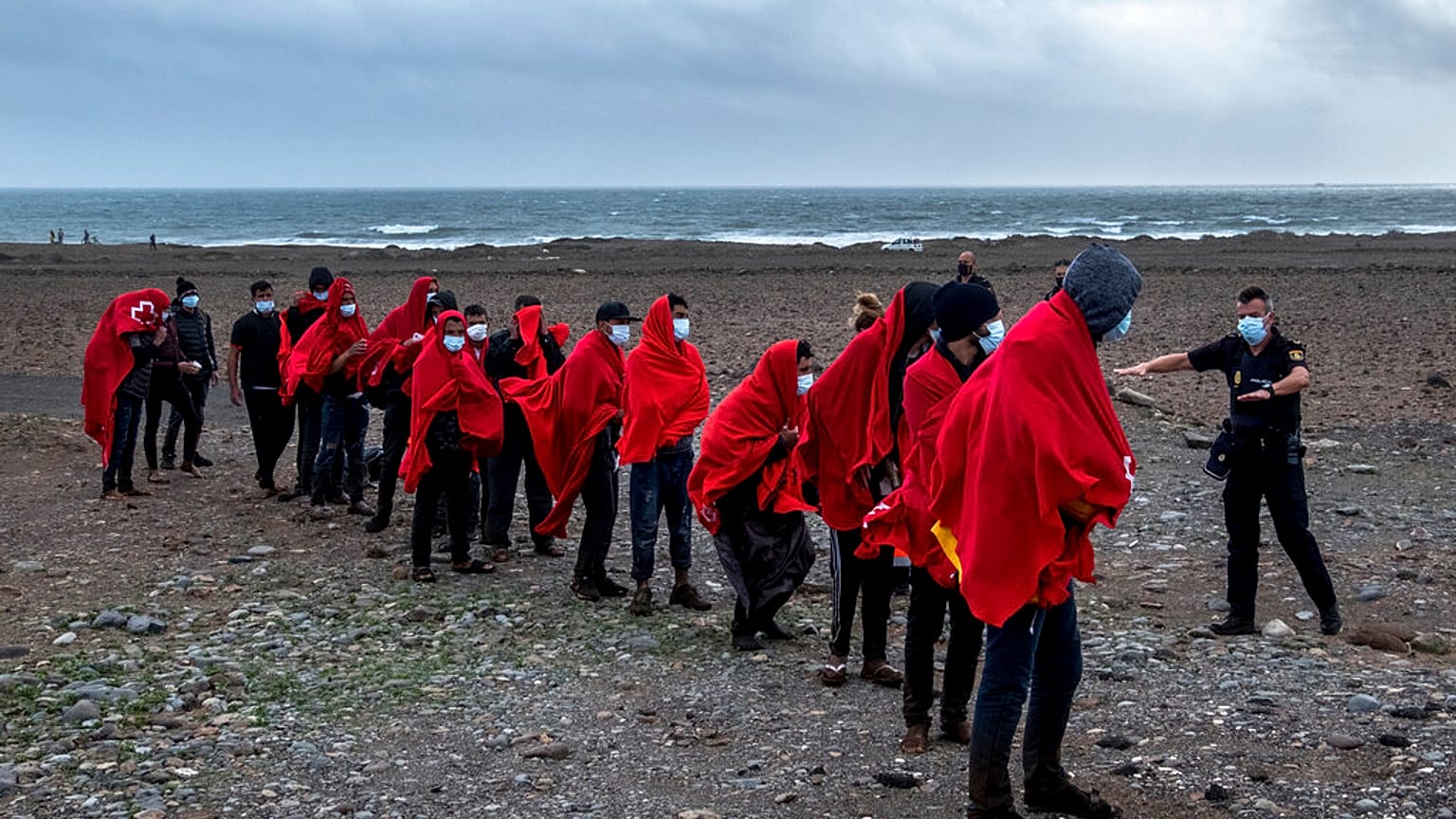 Migrants from Morocco walk on a beach on the Canary island of Gran Canaria, Spain on Friday