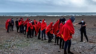 Migrants from Morocco walk on a beach on the Canary island of Gran Canaria, Spain on Friday