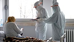 A doctor and nurse take care of patients with COVID-19 at a former military hospital in the capital Sarajevo, Bosnia