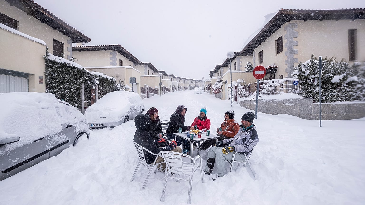 Unos vecinos beben en medio de la calle durante una fuerte nevada en Bustarviejo, en las afueras de Madrid, España, el  9 de enero de 2021.