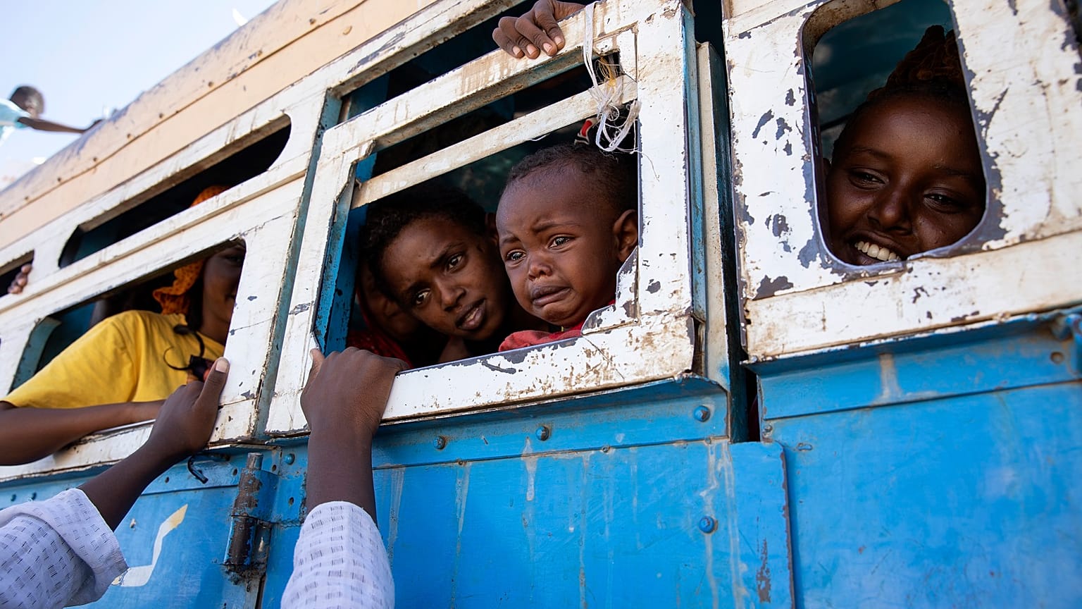 Refugees who fled the conflict in Ethiopia's Tigray region ride a bus going to the Village 8 temporary shelter, near the Sudan-Ethiopia border, in Hamdayet, eastern Sudan.