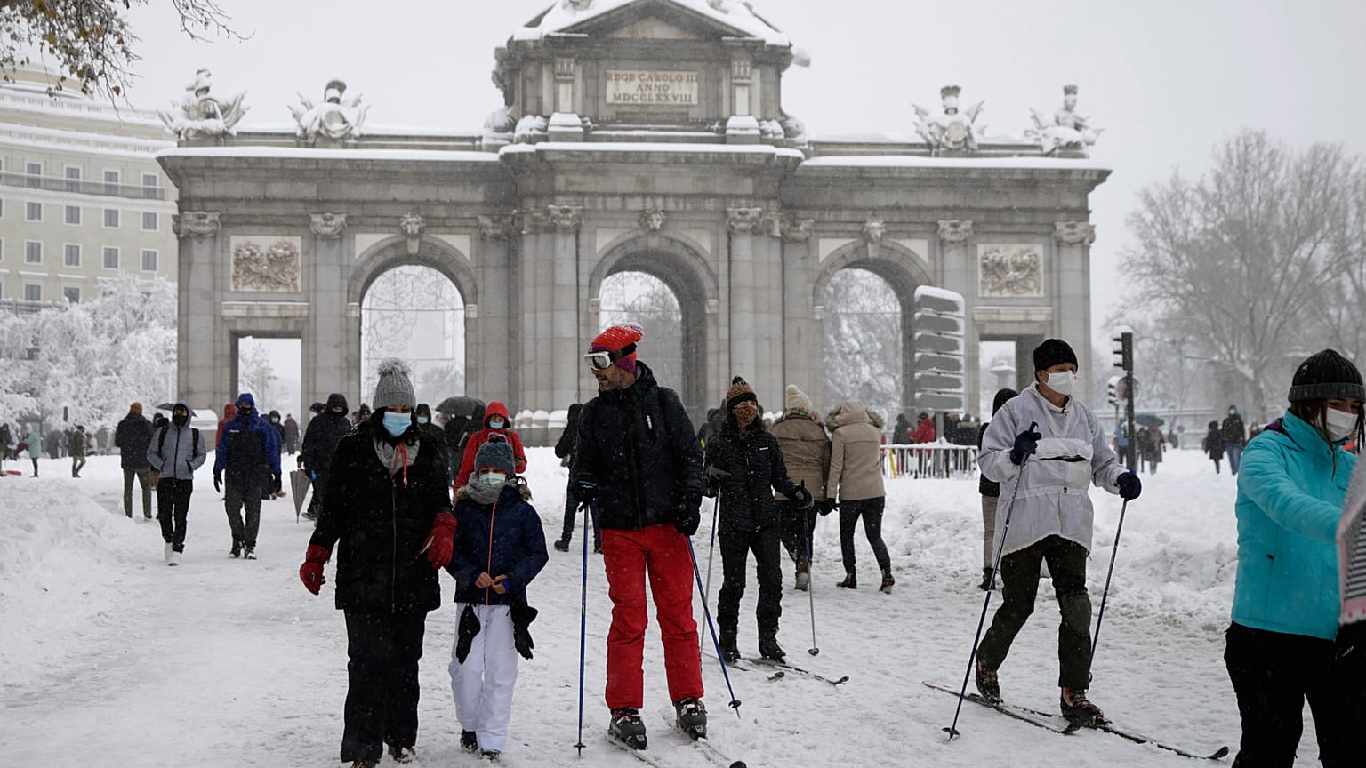 La gente delante de "La Puerta de Alcalá" durante la fuerte nevada en el centro de Madrid, España, el 9 de enero de 2021.