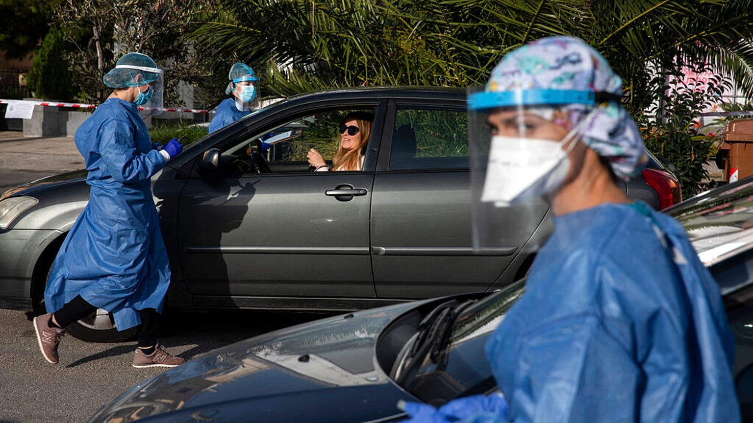 Medical personnel conduct COVID-19 rapid tests of teachers and staff of primary schools at a drive-through testing site