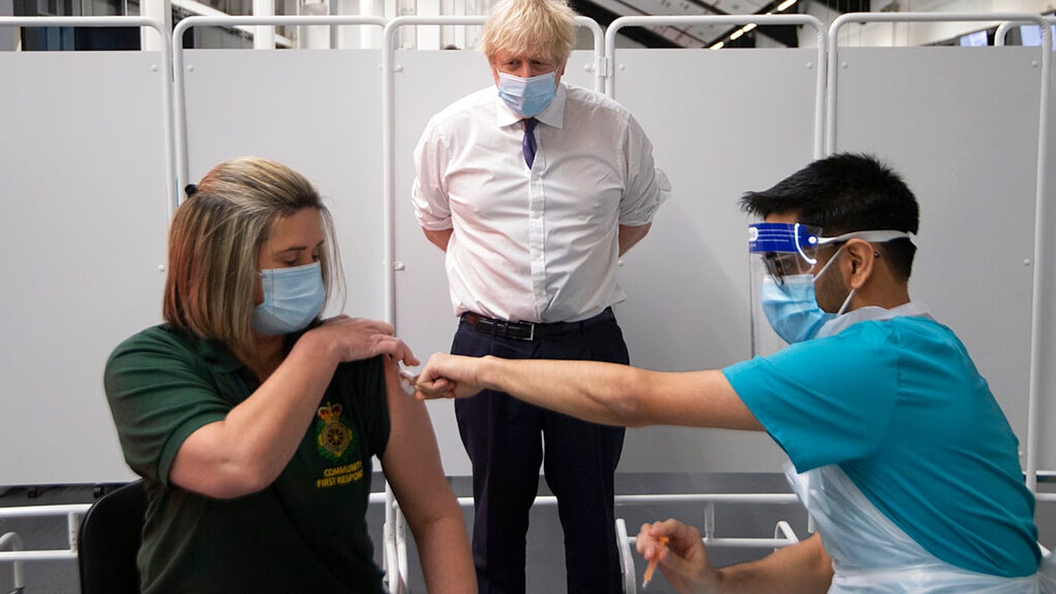 Britain's Prime Minister Boris Johnson watches first responder Caroline Cook receiving an injection of a Covid-19 vaccine at Ashton Gate Stadium in Bristol, England