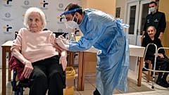 An elderly woman gets a vaccination at a nursing house in Athens