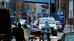 A patient is pushed on a trolley outside the Royal London Hospital in east London, Tuesday, Jan. 12, 2021, during England's third national coronavirus lockdown.