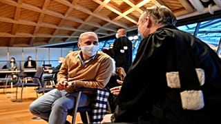 مليكان كوكام مع محاميه قبل محاكمته أمام محكمة أنتويرب الجنائية ، مع تسعة أشخاص آخرين ، بتهم الاتجار بالبشر في 30 نوفمبر، 2020
