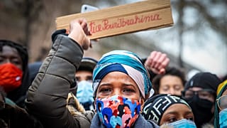 IB's mother takes part in a demonstration on January 13, 2021, outside the police station in Brussels where her son was held