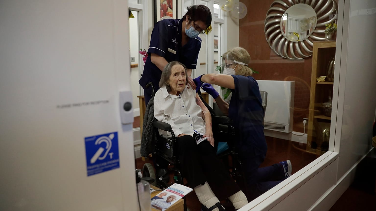 A care home resident receives her first dose of the Oxford/AstraZeneca COVID-19 vaccine