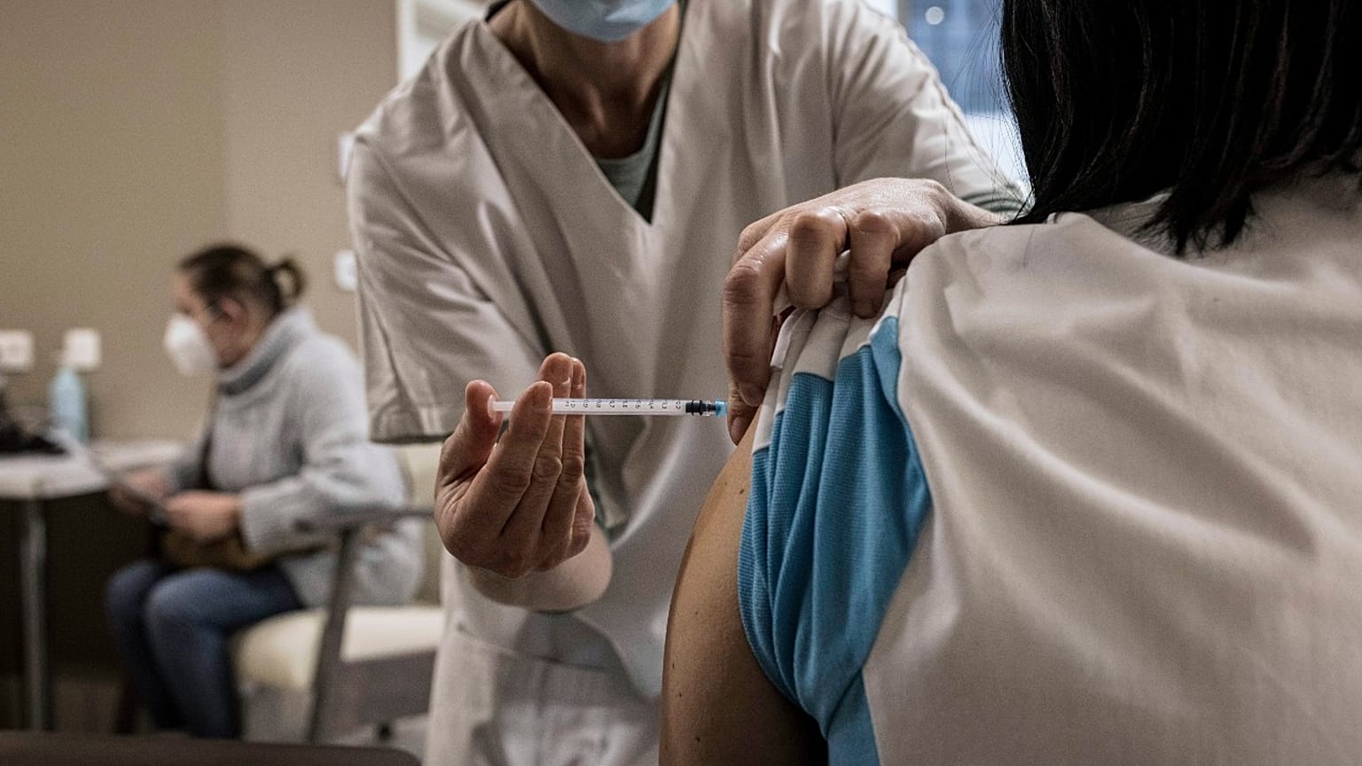 ممرضة تقدم لقاح كوفيد-19  لممرضة أخرى في دار رعاية للمسنين بالقرب من لييج، بلجيكا. 