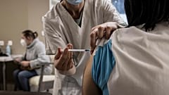 ممرضة تقدم لقاح كوفيد-19  لممرضة أخرى في دار رعاية للمسنين بالقرب من لييج، بلجيكا. 