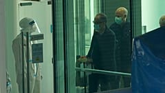 Passengers arriving on the flight from Singapore are processed by staff in protective clothings and directed towards a covered walkway to a separate exit from the airport.