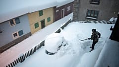 Frau beim Schippen von Schnee in Valens in der Schweiz