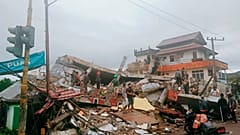 Residents inspect earthquake-damaged buildings in Mamuju, West Sulawesi, Indonesia, Friday, Jan. 15