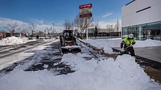 Workers remove snow at a parking lot in Alcobendas, outskirts of Madrid, Spain, Friday, Jan. 15, 2021.(AP Photo/Bernat Armangue)