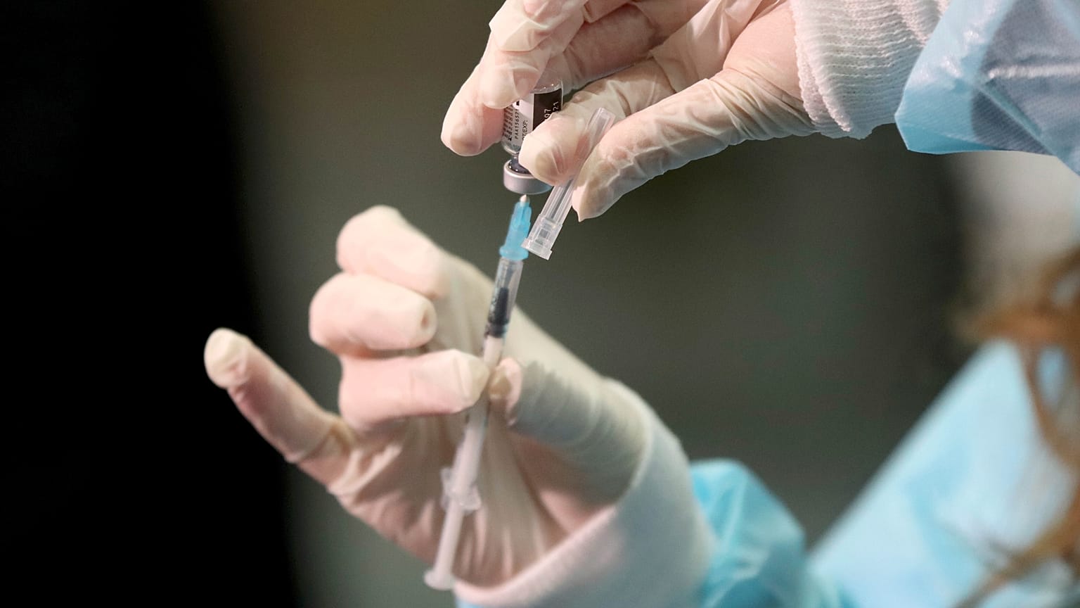 A medical worker holding a Pfizer-BioNTech vaccine and a syringe during mass vaccination starts in Vienna, Austria, Friday, Jan. 15, 2021. 