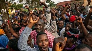 Supporters of leading opposition challenger Bobi Wine cheer as election officials count the ballots after polls closed in Kampala, Uganda, Thursday, Jan. 14, 2021.