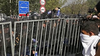 Hungarian police use pepper spray on migrants at the "Horgos 2" border crossing into the Hungary, near Horgos, Serbia, Wednesday, Sept. 16, 2015.