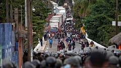 Honduran migrants, top, confront Guatemalan soldiers and police manning a roadblock on the highway in Vado Hondo, Guatemala, Monday, Jan. 18, 2021. 