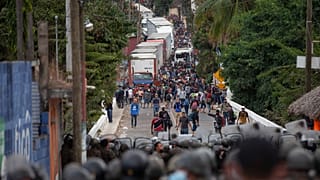 Honduran migrants, top, confront Guatemalan soldiers and police manning a roadblock on the highway in Vado Hondo, Guatemala, Monday, Jan. 18, 2021. 