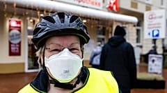 A woman with a FFP2 mask stands in front of a pharmacy in Kiel, northern Germany, Tuesday, Dec. 15, 2020