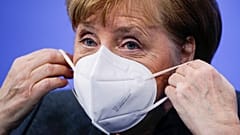 German Chancellor Angela Merkel puts on a face mask after a news conference on further coronavirus measures, at the Chancellery in Berlin, Germany, Jan. 19, 2021.