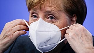 German Chancellor Angela Merkel puts on a face mask after a news conference on further coronavirus measures, at the Chancellery in Berlin, Germany, Jan. 19, 2021.