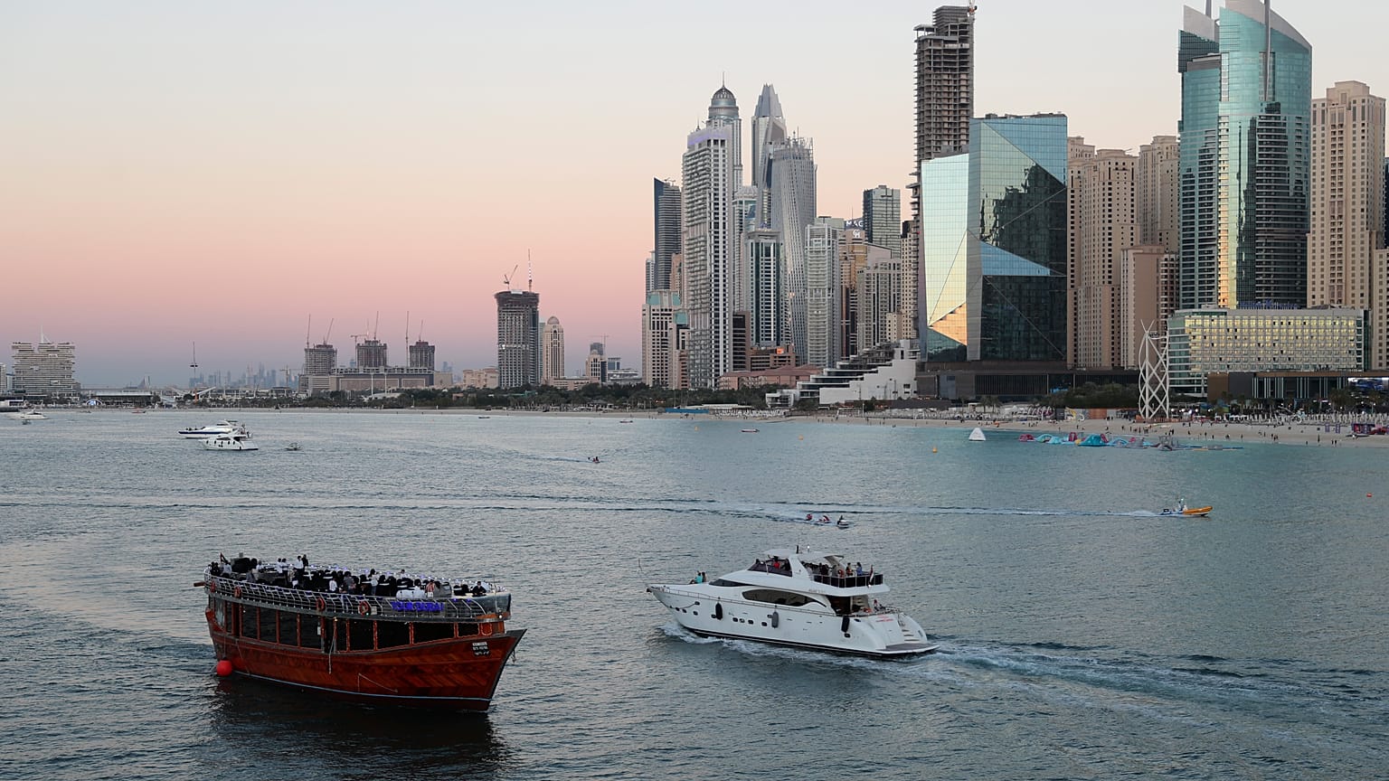 Tourists on a yacht pass a traditional show in Dubai, United Arab Emirates, Tuesday, Jan. 12, 2021.