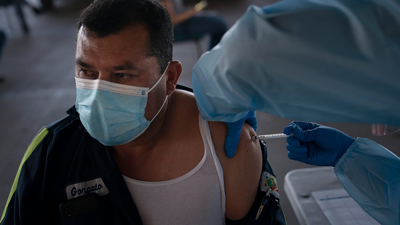 Un obrero agrícola es vacunado contra la COVID en California