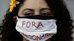 Διαδηλώτρια κατά του Μπολσονάρο στη Βραζιλία, μία από τις χώρες με θλιβερό ρεκόρ κρουσμάτων και θανάτων Covid-19