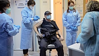 In this photo taken on Friday, Jan. 15, 2021 a Romanian gendarme gets a COVID-19 vaccine at a hospital in Bucharest, Romania.