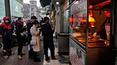 Residentes de Wuhan aguardam para ser entendidos numa banca de comida