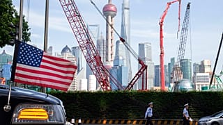 Sanghaj látképe, az előtérben egy amerikai követségi autó orrával