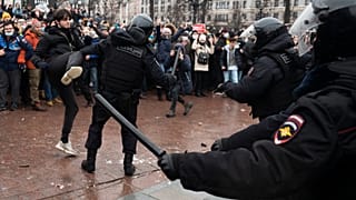 A demonstrator clashes with a police officer during a protest against the jailing of opposition leader Alexei Navalny in Moscow, Russia, Jan. 23, 2021