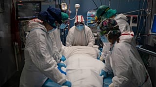 Varios sanitarios se preparan para rotar a un paciente de COVID en el Hospital del Mar, en Barcelona