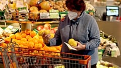 Una donna indossa una Ffp2 al supermercato, Vienna