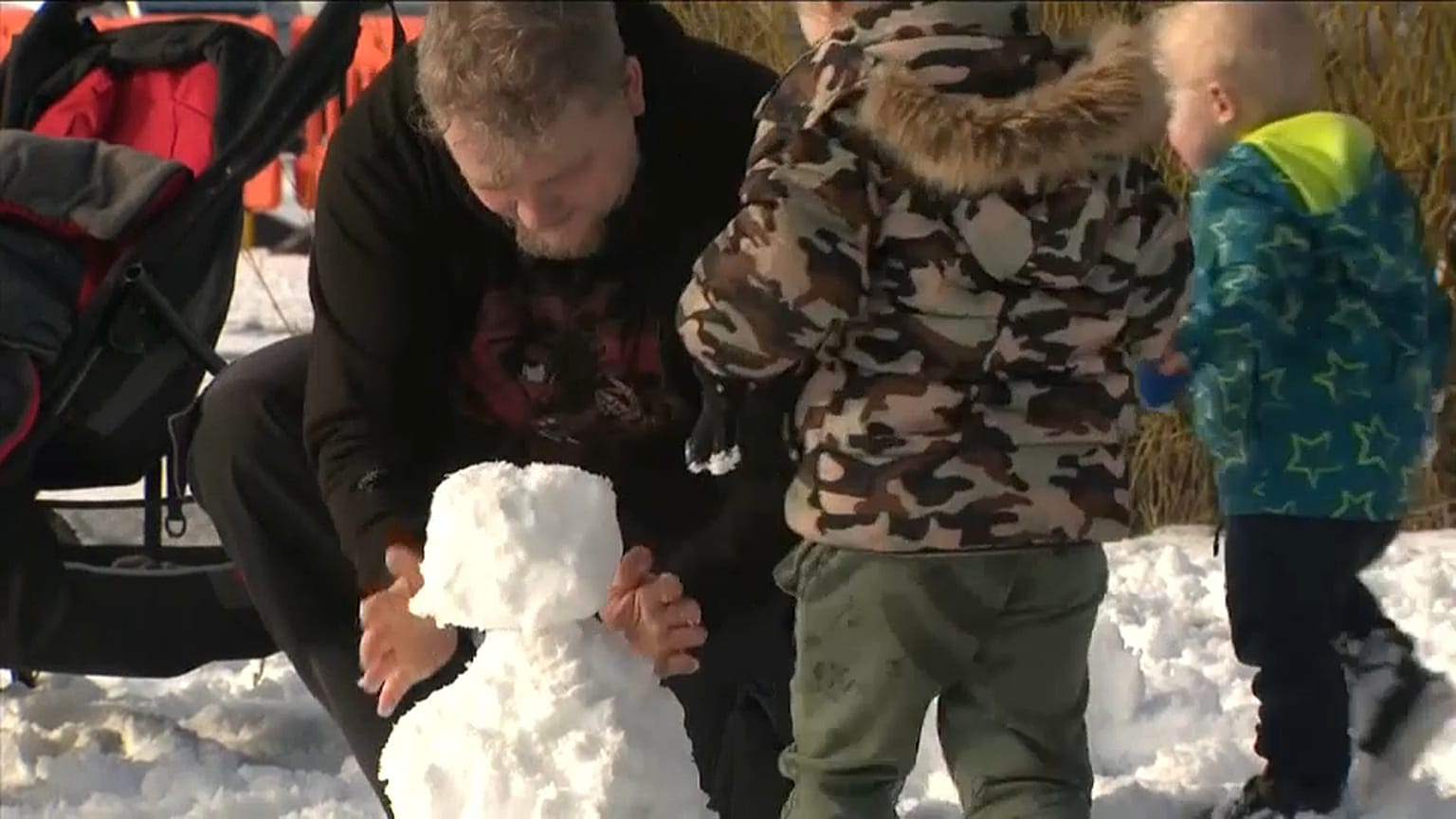 Vater baut Schneemann mit dem Sohn