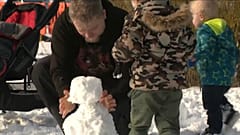 Vater baut Schneemann mit dem Sohn