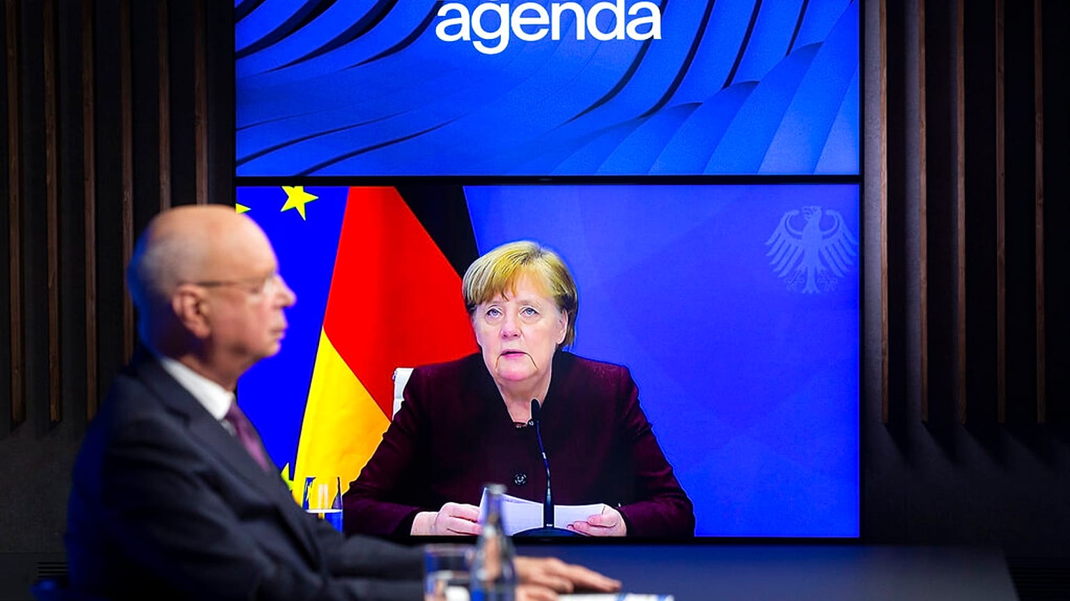German Klaus Schwab, left, Founder and Executive Chairman of the World Economic Forum, WEF, listens to German Chancellor Angela Merkel