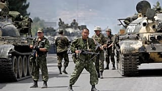 In this Thursday, Aug. 14, 2008 file photo, Russian soldiers block the road on the outskirts of Gori, northwest of the capital Tbilisi, Georgia.