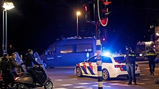 A police officers speaks to youths on scooters at a road block in Amsterdam on Tuesday night.