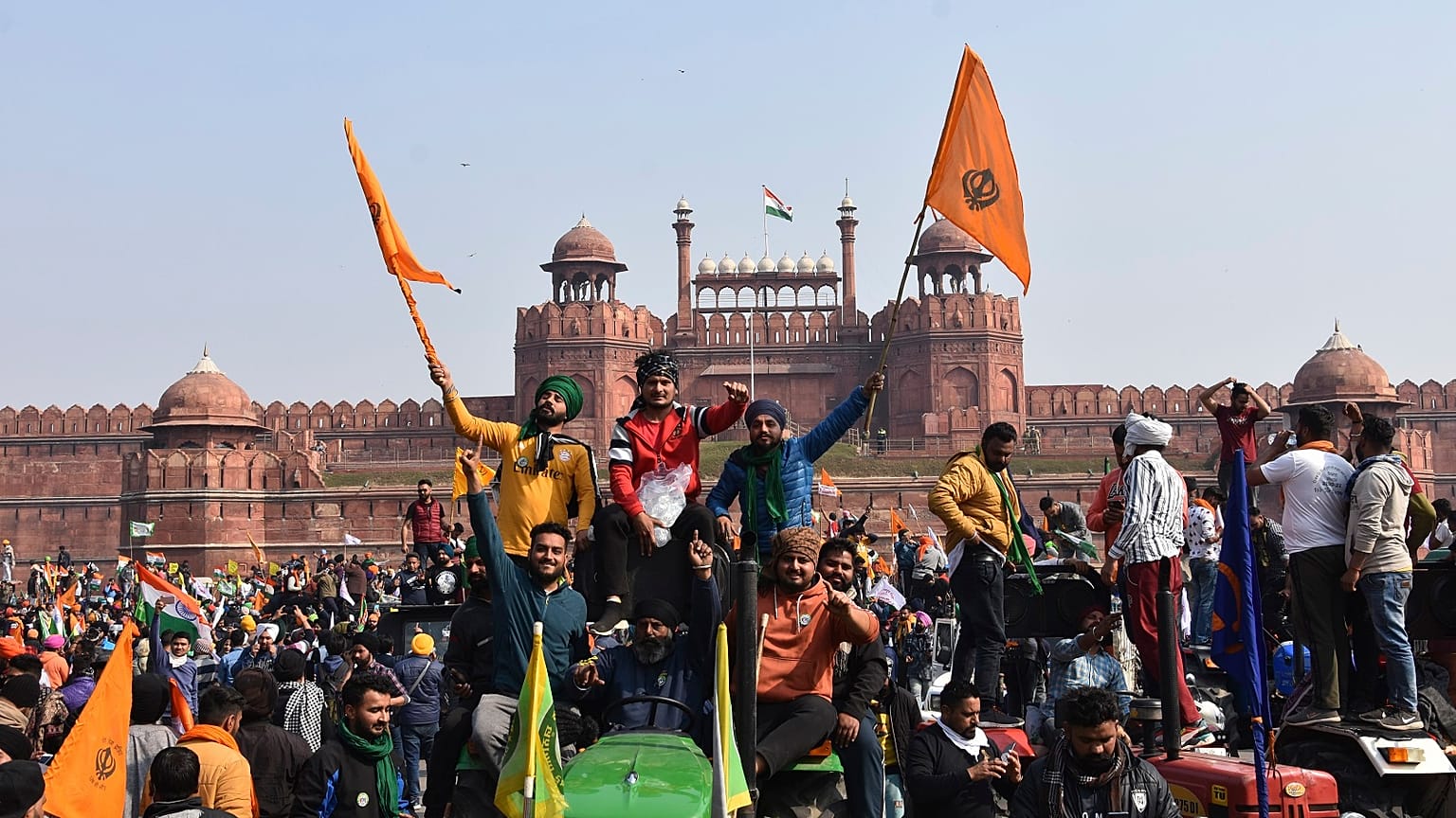 Sikhs wave the Nishan Sahib, a Sikh religious flag, as they arrive at the historic Red Fort monument in New Delhi, India, Tuesday, Jan. 26, 2021.