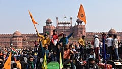 Sikhs wave the Nishan Sahib, a Sikh religious flag, as they arrive at the historic Red Fort monument in New Delhi, India, Tuesday, Jan. 26, 2021.
