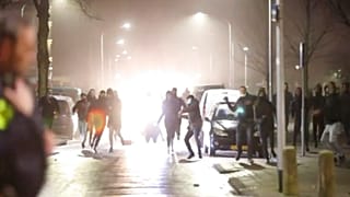 In this grab taken from video on Monday, Jan, 25, 2021, rioters throw stones at police, in Haarlem, Netherlands