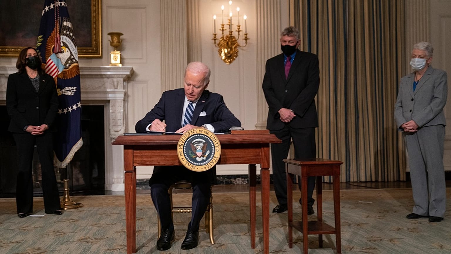 President Joe Biden signs a series of executive orders on climate change, in the State Dining Room of the White House, Wednesday, Jan. 27, 2021, in Washington. 