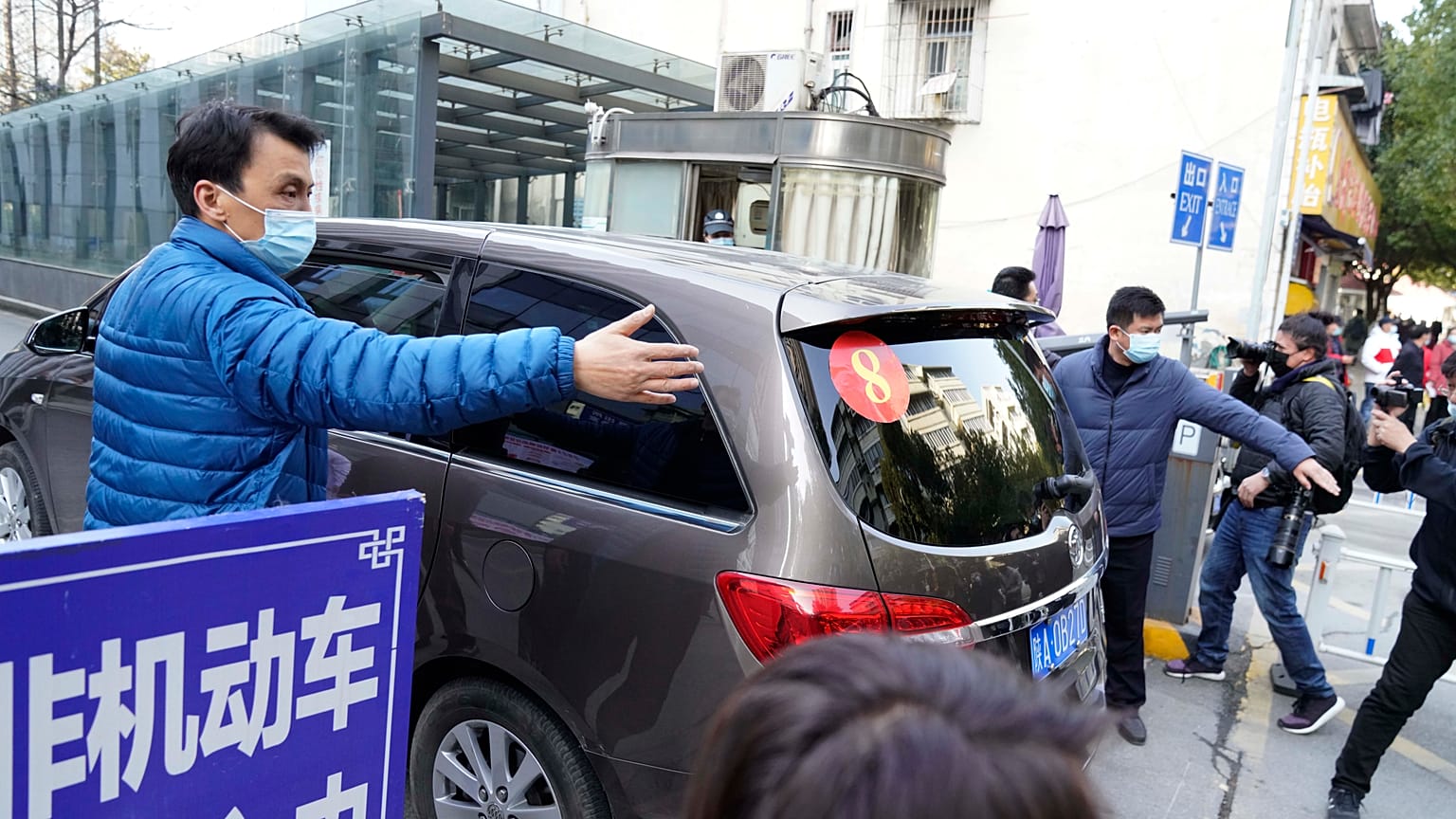 A car that's part of a convoy carrying the World Health Organization team of researchers arrives at the Hubei Province Xinhua Hospital in Wuhan on Friday, Jan. 29.