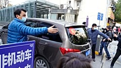 A car that's part of a convoy carrying the World Health Organization team of researchers arrives at the Hubei Province Xinhua Hospital in Wuhan on Friday, Jan. 29.